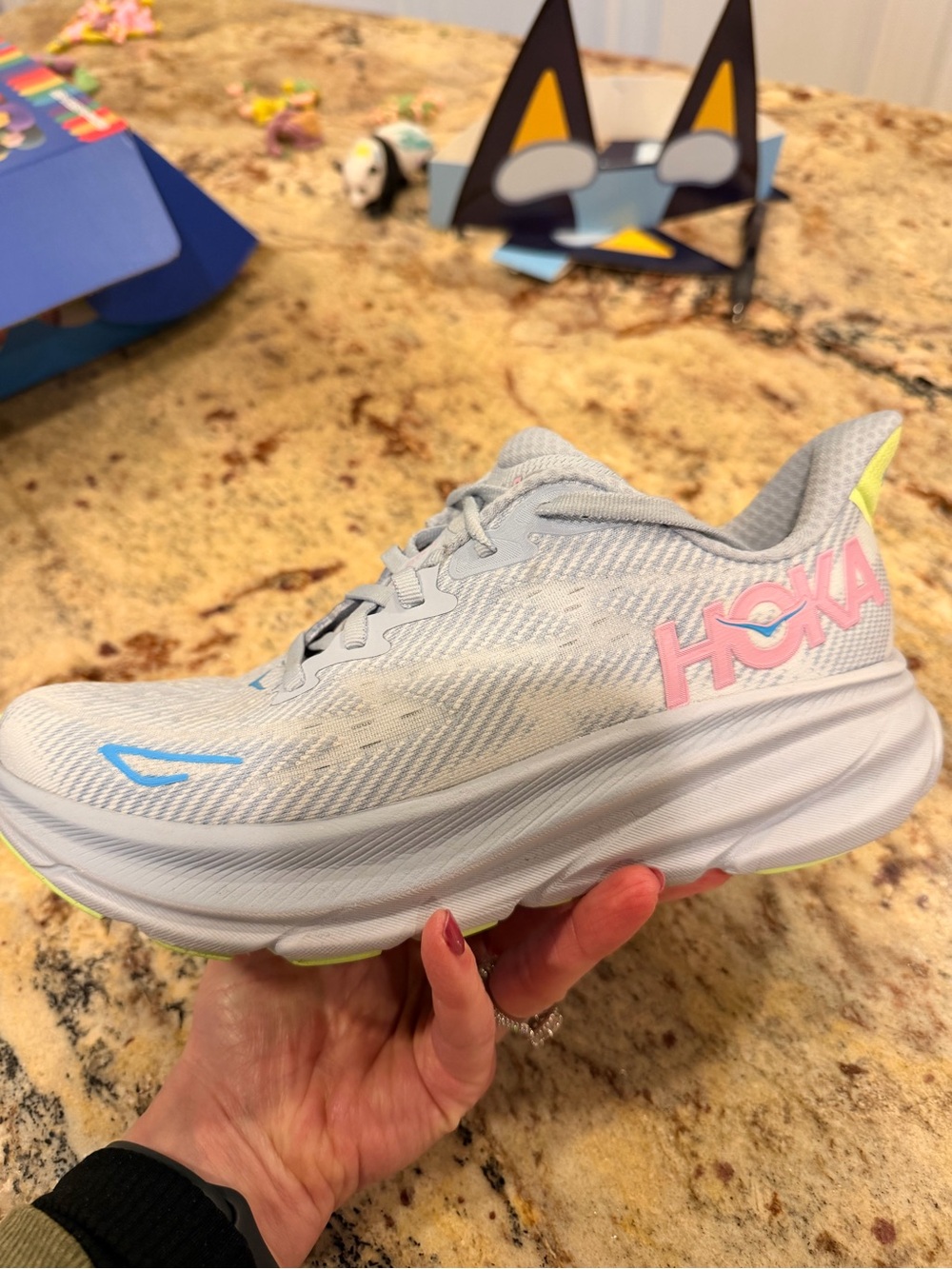 Hoka Women's Light Gray Running Shoe with Pink Logo and Blue Accents